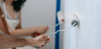 Perfecting Your House Painting: A Comprehensive Guide Two people painting the wall