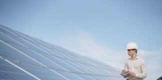 How Do Roofing Contractors Tackle Solar Panel Integration? Solar technician inspecting solar panel