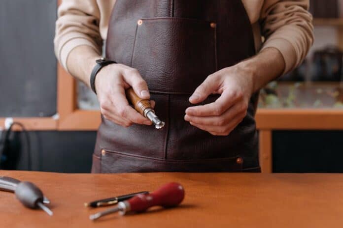 Person Holding a Leather Workshop Tool