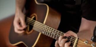 8 Simple Fastener Mistakes That Ruin Great Guitars Over Time Person Playing Brown Guitar