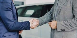 5 Essential Steps to Take Before You Visit a Car Dealership Two businessmen shaking hands in a car dealership